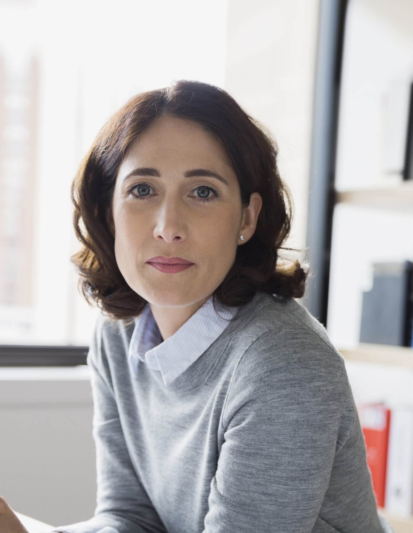 A woman in her forties in natural window light during a hormone therapy consultation at Pulse Health & Wellness